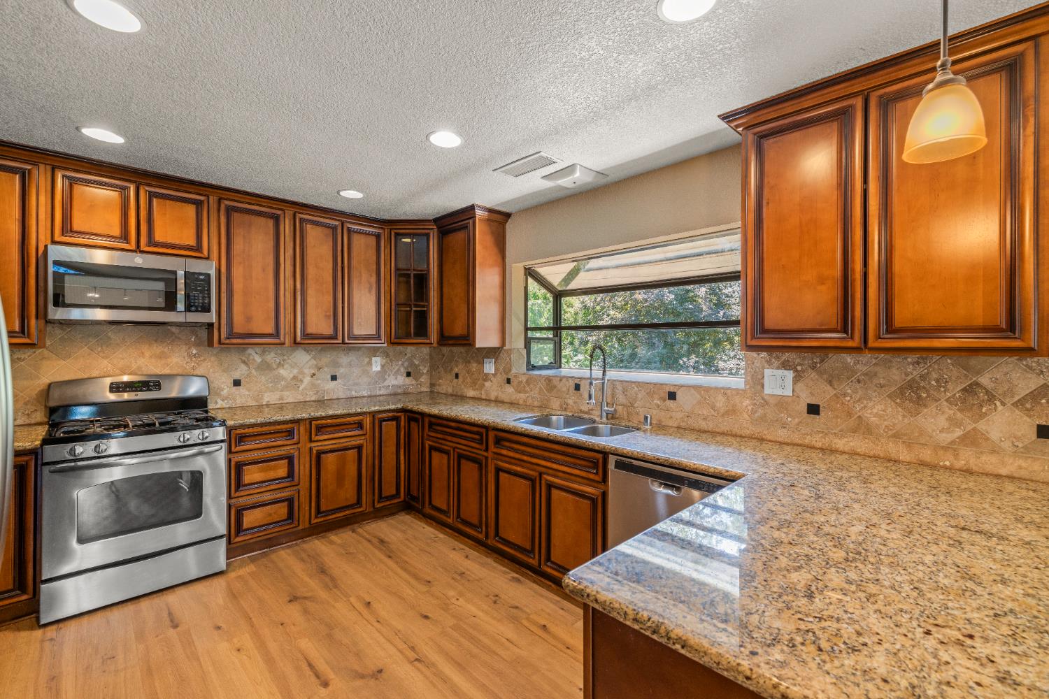 24126 Green Valley Road Auburn, CA 95602 - Photo 8 of 65 a kitchen with stainless steel appliances granite countertop wooden cabinets a sink and a stove