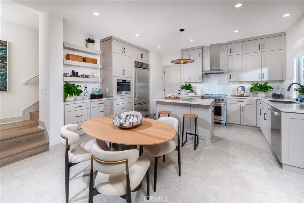 136 Pisano Irvine, CA 92618 - Photo 4 of 4 a kitchen with stainless steel appliances kitchen island granite countertop a dining table chairs and white cabinets