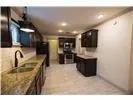 a kitchen with stainless steel appliances kitchen island a large counter top a stove and a sink