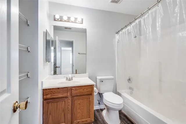 a bathroom with a sink a toilet a mirror and shower curtain