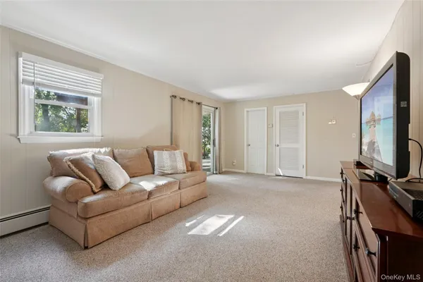 a living room with furniture a window and a flat screen tv