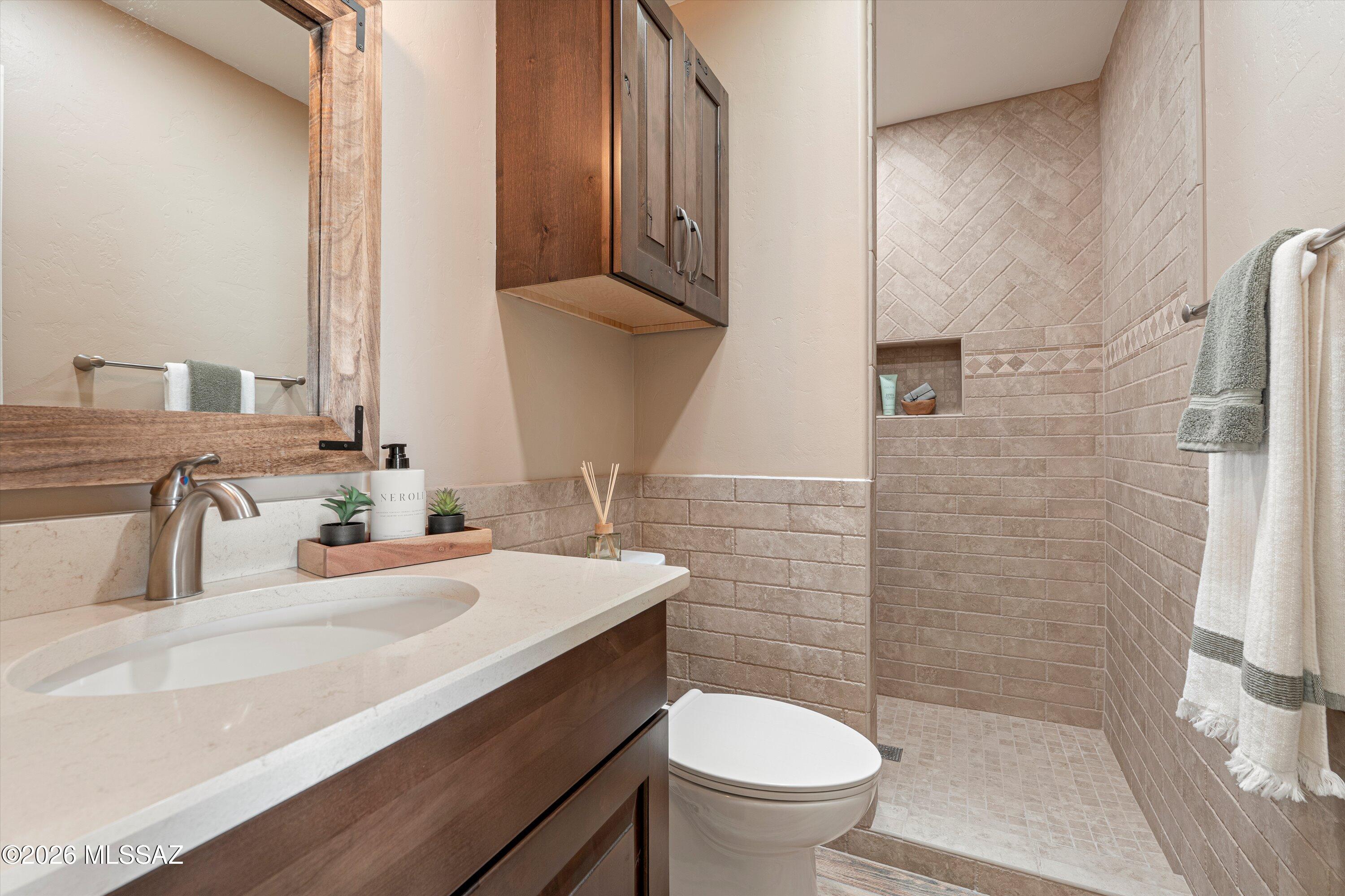 4760 East Wagon Train Road Tucson, AZ 85739 - Photo 25 of 38 a bathroom with a sink a toilet and shower