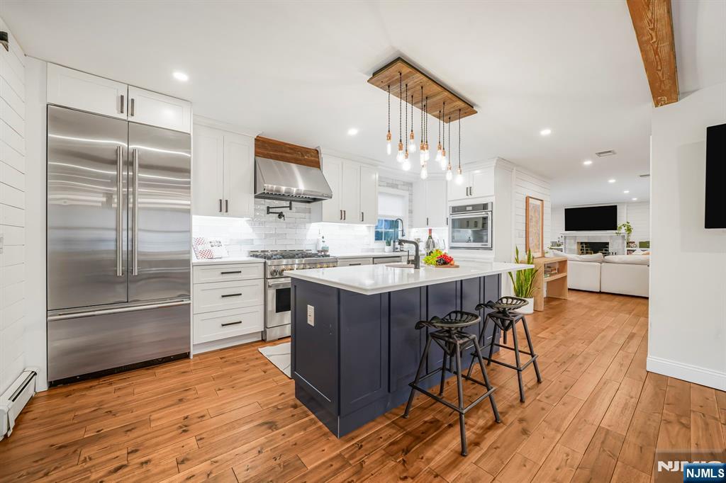 10 Winonah Avenue Wayne, NJ 07470 - Photo 8 of 41 a kitchen with stainless steel appliances kitchen island granite countertop a refrigerator and a stove top oven