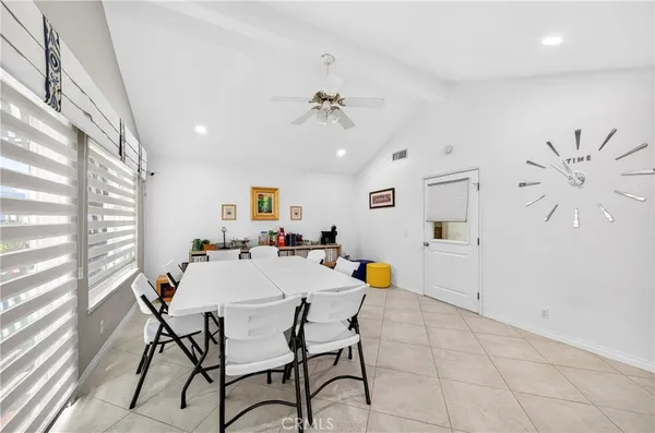 a kitchen with stainless steel appliances granite countertop a stove top oven a sink dishwasher a dining table and chairs with wooden floor