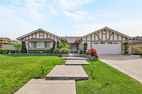 a view of house with outdoor space and parking