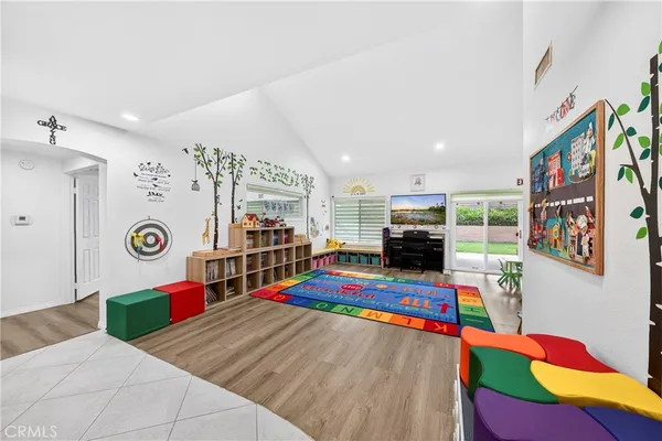 a living room with furniture and a dining table with bookshelf