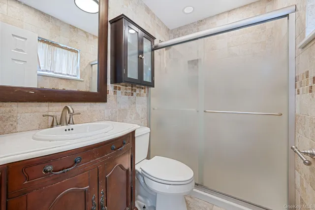 a bathroom with a sink a toilet and mirror