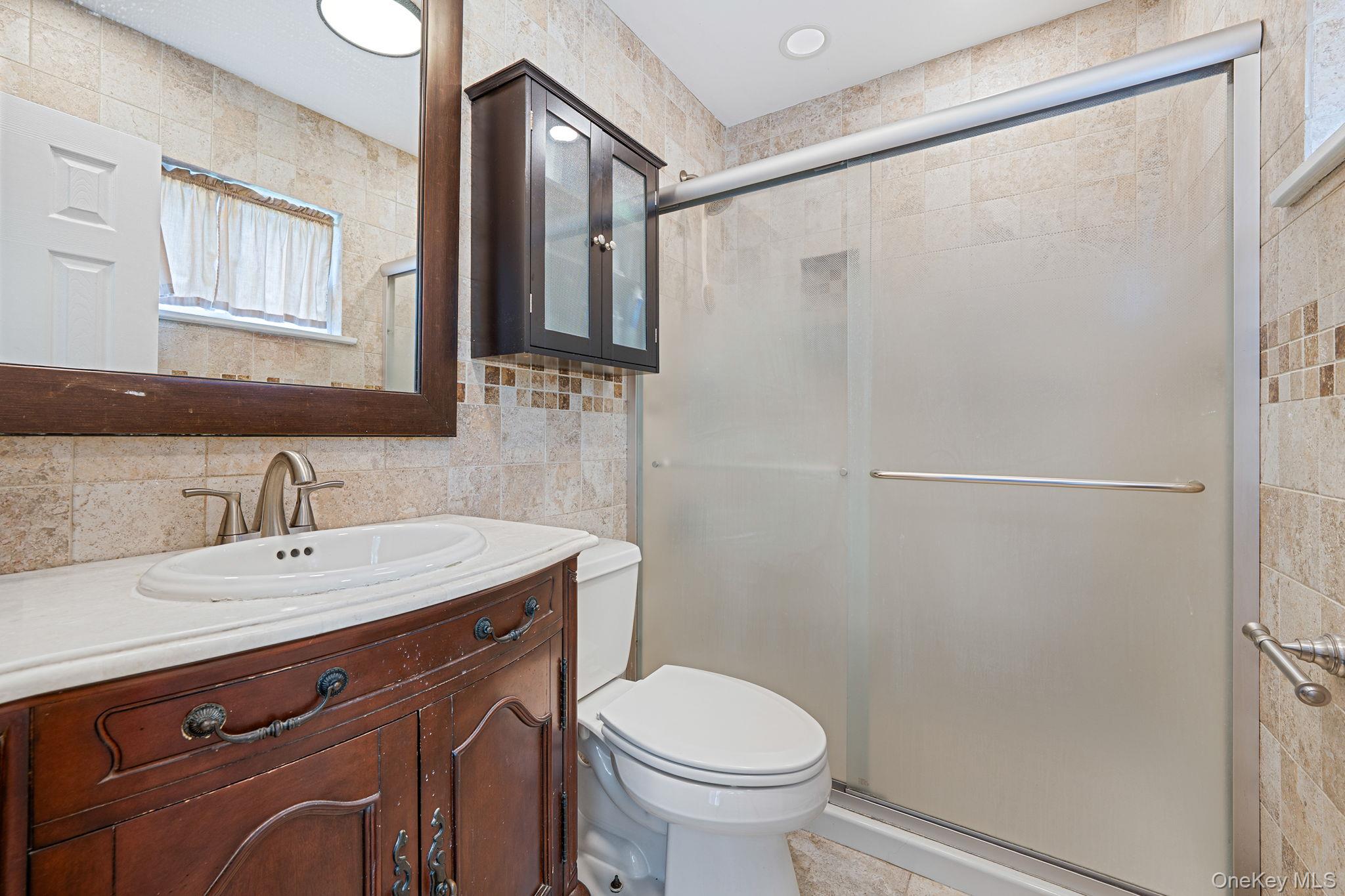 5 Hastings Drive Ridge, NY 11961 - Photo 14 of 31 a bathroom with a sink a toilet and mirror