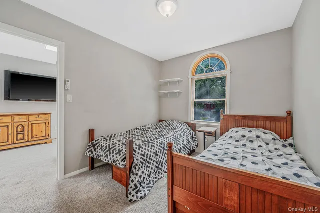 a bedroom with two beds and a flat screen tv