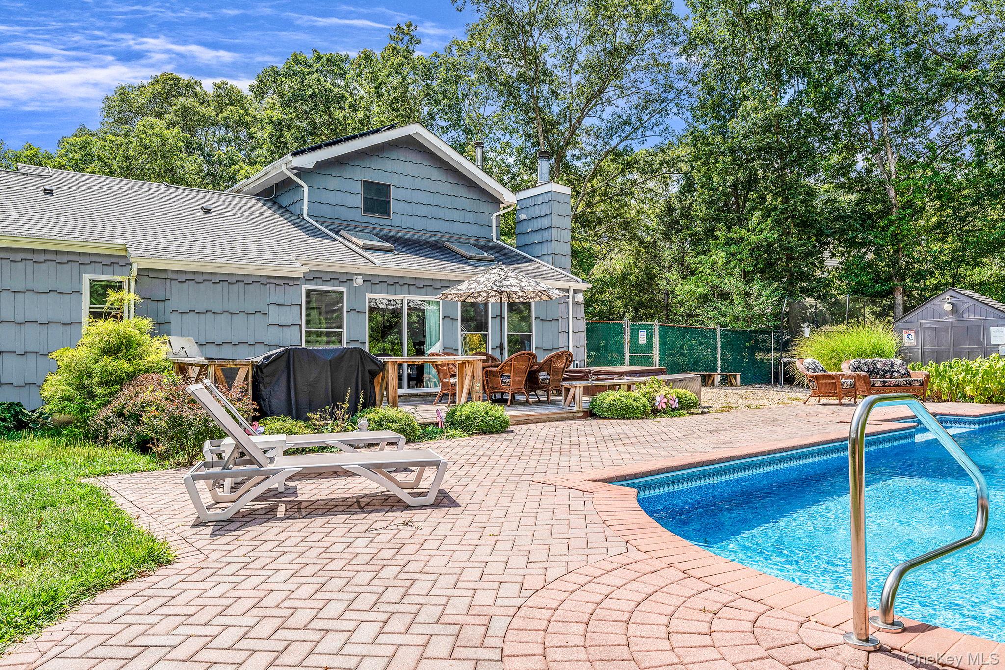 5 Hastings Drive Ridge, NY 11961 - Photo 27 of 31 a view of a patio with table and chairs under an umbrella with wooden fence