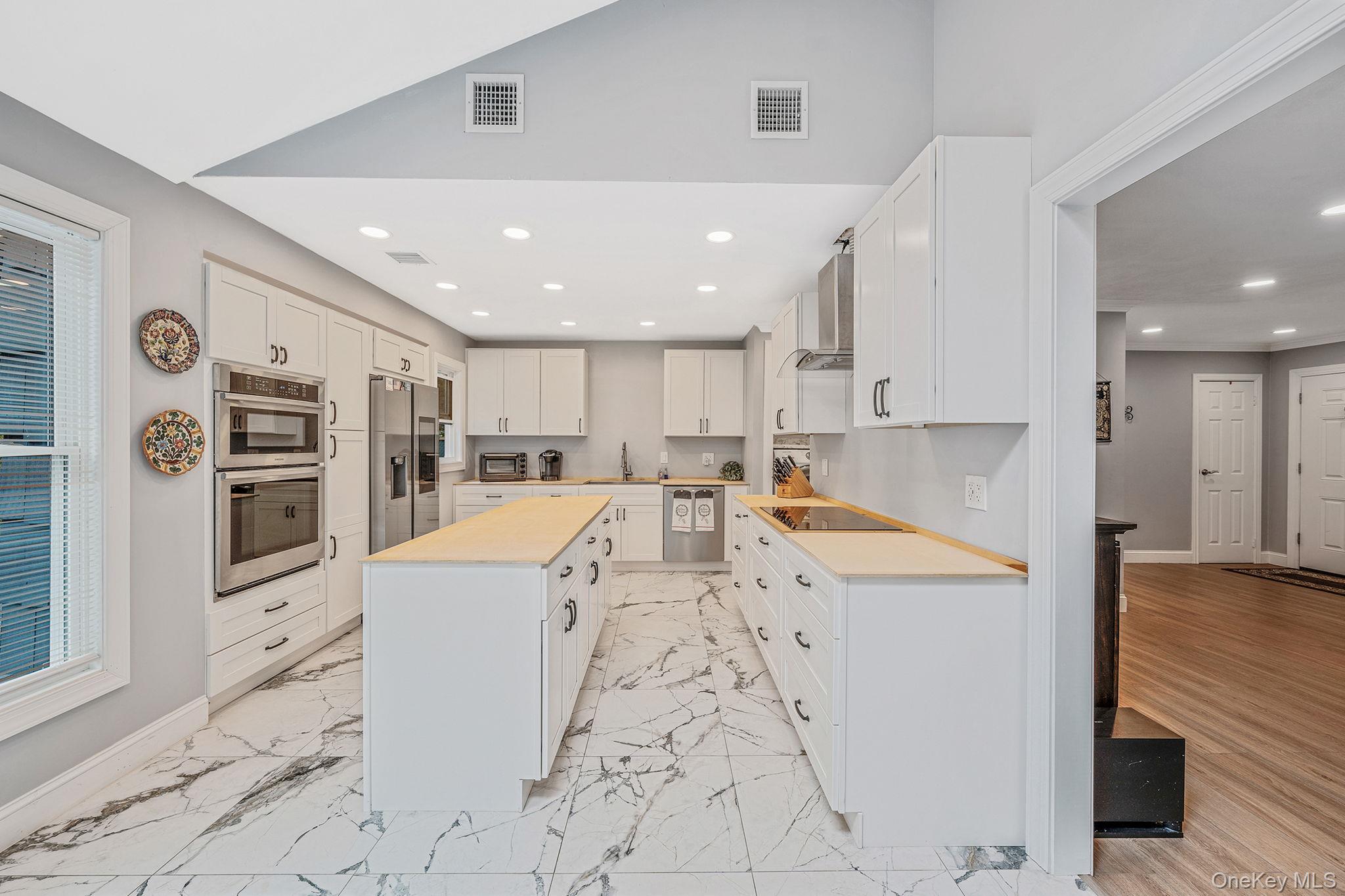 5 Hastings Drive Ridge, NY 11961 - Photo 6 of 31 a large white kitchen with lots of counter space and stainless steel appliances