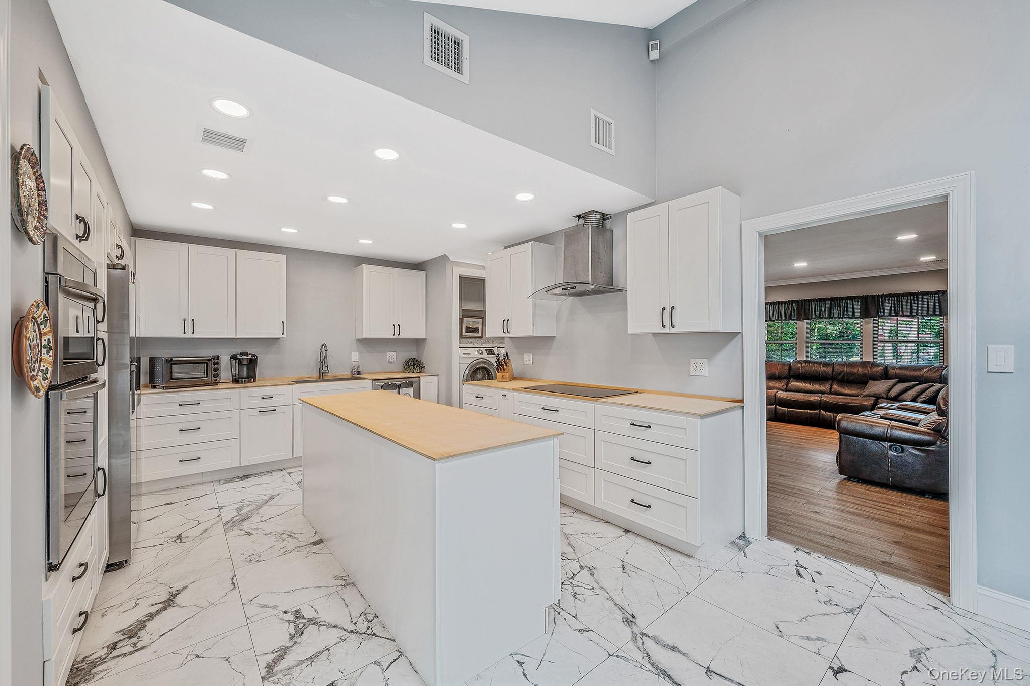 5 Hastings Drive Ridge, NY 11961 - Photo 7 of 31 a large white kitchen with cabinets