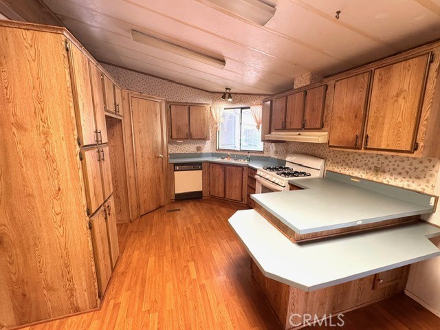 27701 Murrieta Road, Unit 255 Menifee, CA 92586 - Photo 9 of 20 a kitchen with stainless steel appliances a refrigerator a sink dishwasher a stove and white countertops with wooden floor
