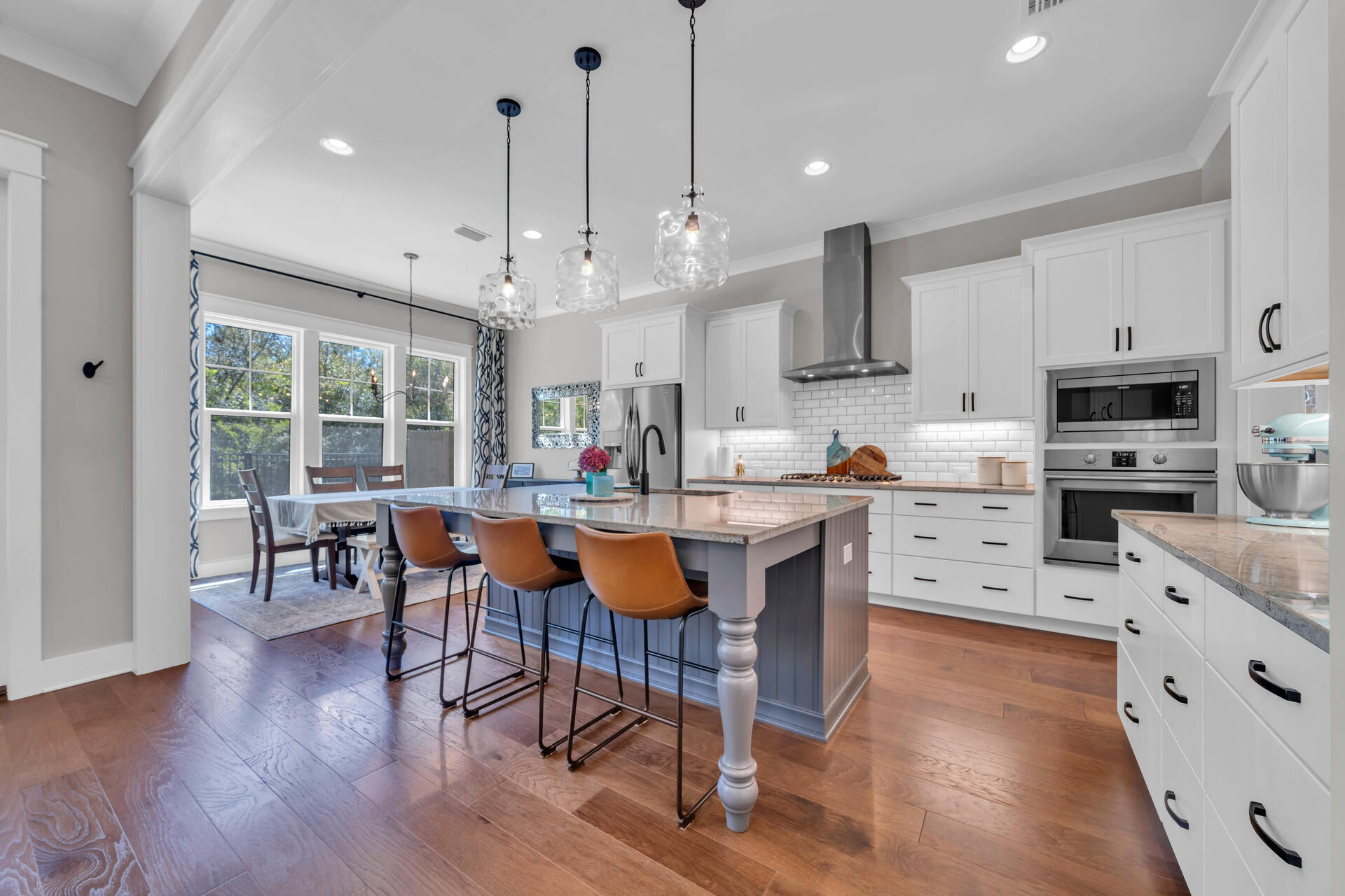1244 Elderflower Drive Niceville, FL 32578 - Photo 11 of 74 a kitchen with stainless steel appliances granite countertop a stove top oven a refrigerator a sink and a dining table with wooden floor