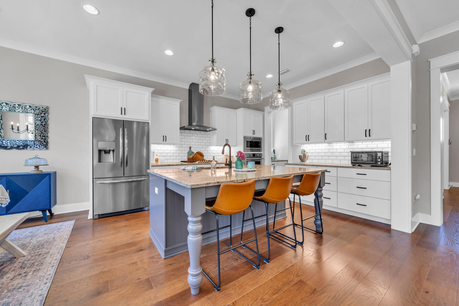 1244 Elderflower Drive Niceville, FL 32578 - Photo 14 of 74 a kitchen with stainless steel appliances kitchen island granite countertop a refrigerator a stove a sink a island and chairs with wooden floor
