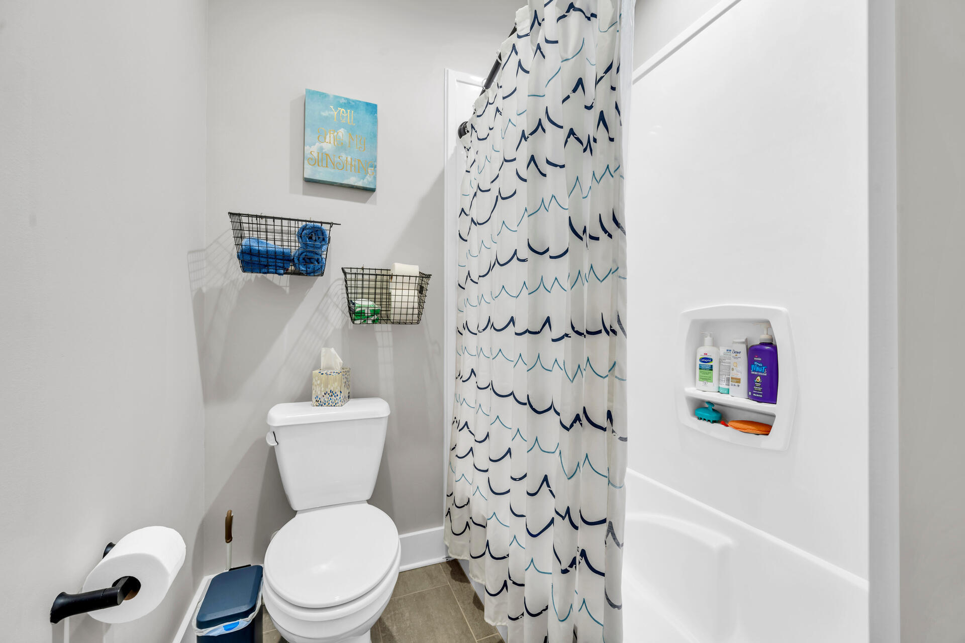 1244 Elderflower Drive Niceville, FL 32578 - Photo 50 of 74 a white toilet sitting next to a shower curtain