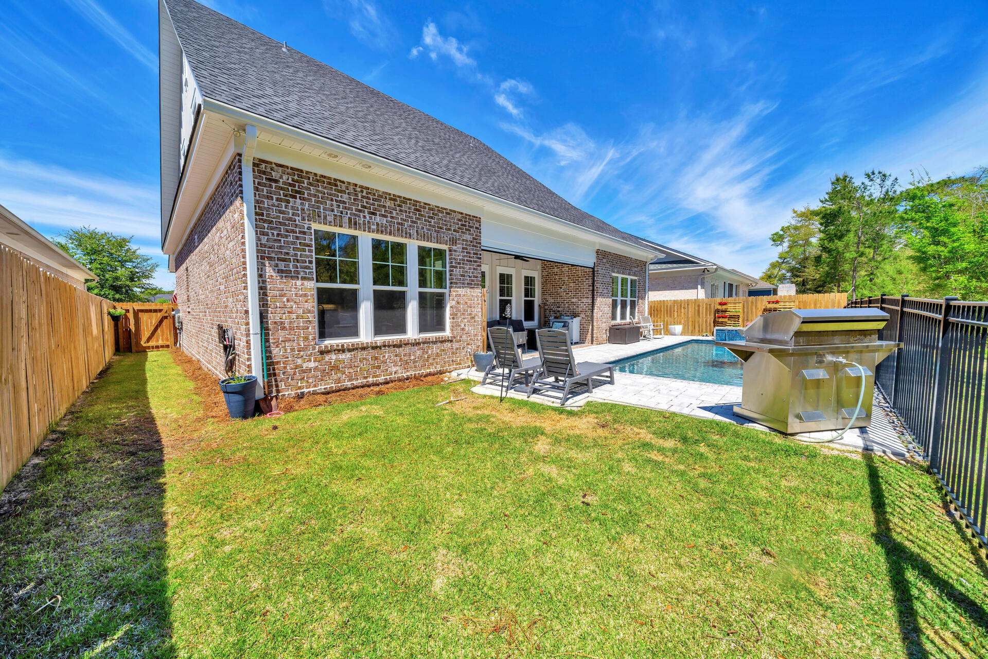 1244 Elderflower Drive Niceville, FL 32578 - Photo 65 of 74 a view of a backyard with table and chairs with wooden fence and plants