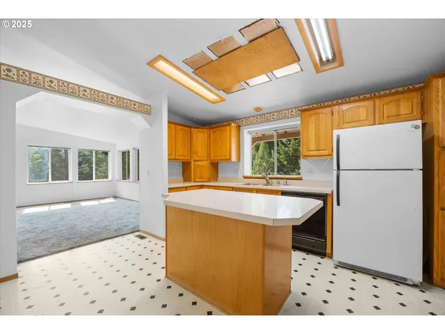 a kitchen with stainless steel appliances a stove a sink a refrigerator and cabinets