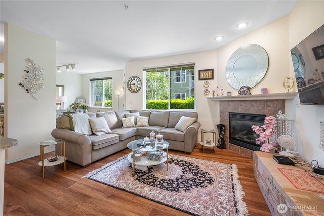 a living room with furniture a fireplace and a large window