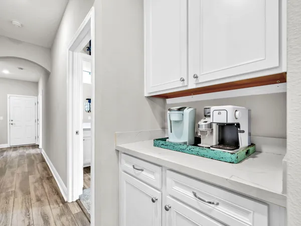 a kitchen with white cabinets and a wooden floor