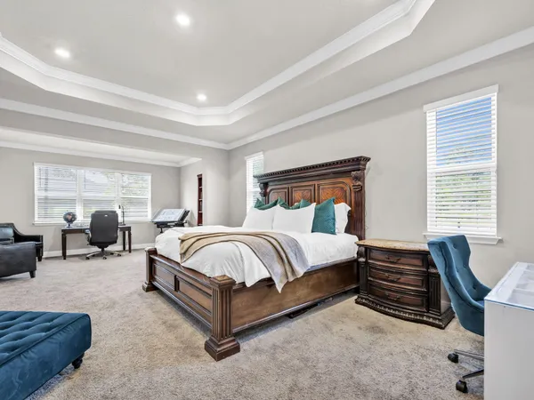 a spacious bedroom with a bed a couch and dresser