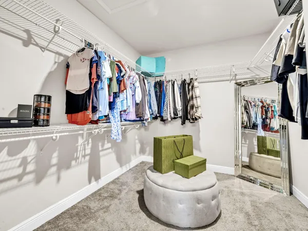 a view of walk in closet with clothes and shoes