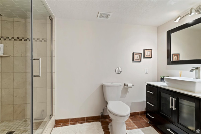 1924 North 2000th Street East Layton, UT 84040 - Photo 31 of 41 Full bath featuring vanity, a shower stall, dark tile patterned floors, and a textured ceiling