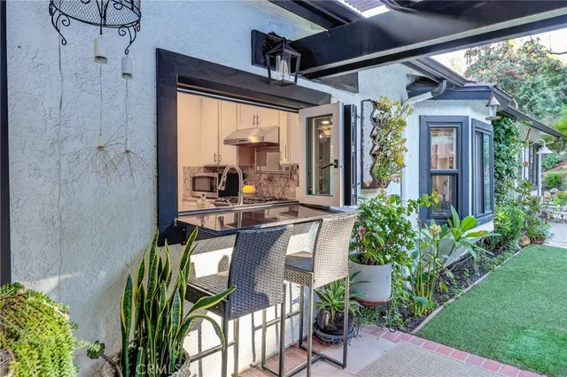 a backyard of a house with a garden and outdoor seating