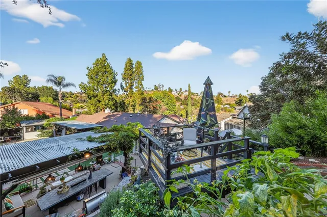a view of a patio with table and chairs potted plants and a large tree
