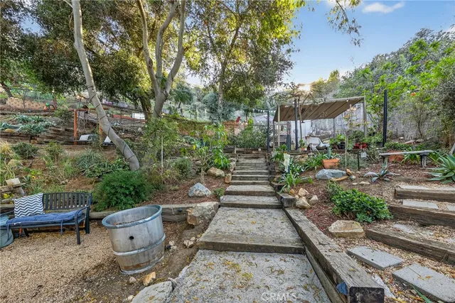 a view of a patio with table and chairs potted plants and floor to ceiling window and wooden fence