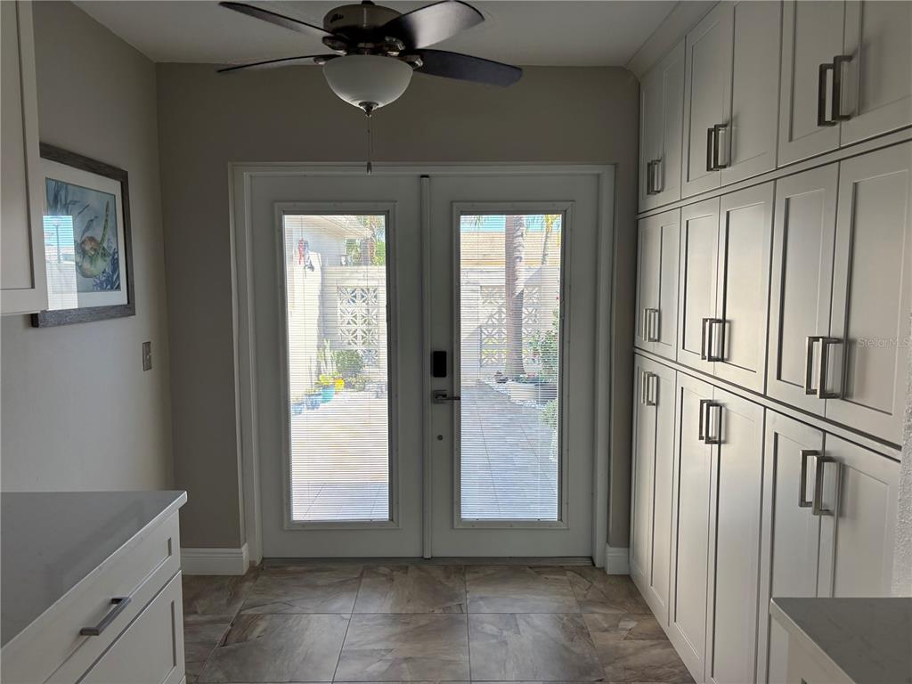 457 Boca Ciega Point Boulevard North St. Petersburg, FL 33708 - Photo 5 of 13 an empty room with wooden floor cabinet and windows