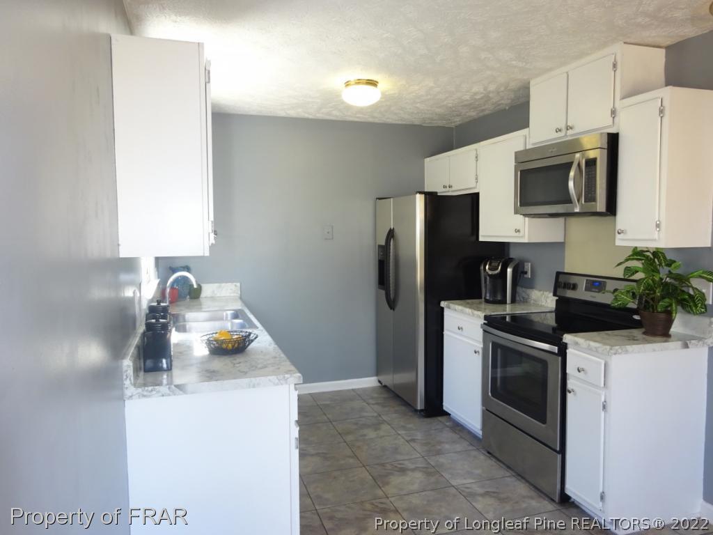 6528 Applewhite Road Fayetteville, NC 28304 - Photo 4 of 15 a kitchen with a sink and steel appliances
