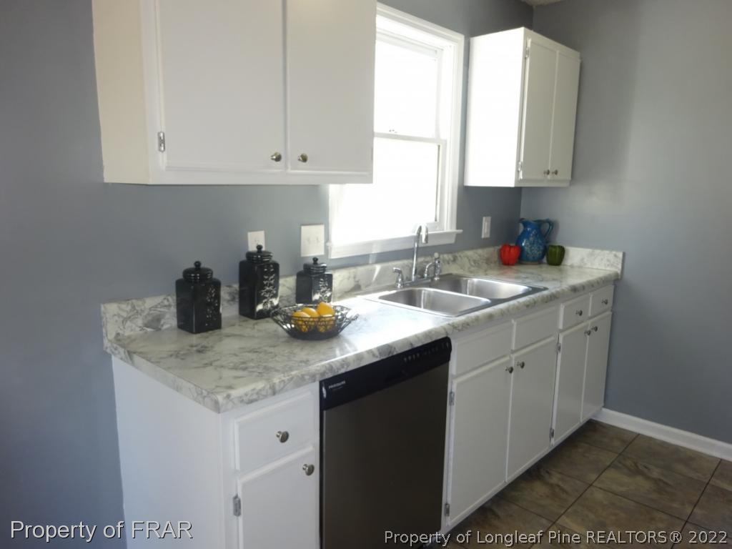 6528 Applewhite Road Fayetteville, NC 28304 - Photo 5 of 15 a kitchen with stainless steel appliances granite countertop a sink stove and white cabinets