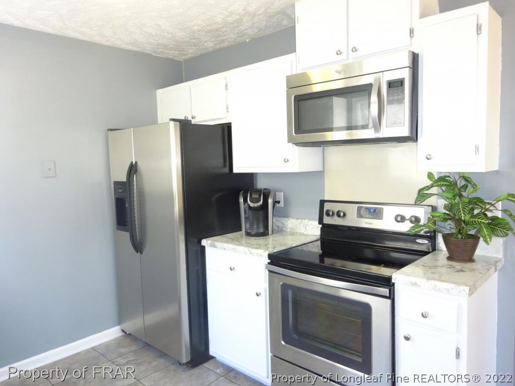 6528 Applewhite Road Fayetteville, NC 28304 - Photo 6 of 15 a kitchen with a stove and a microwave