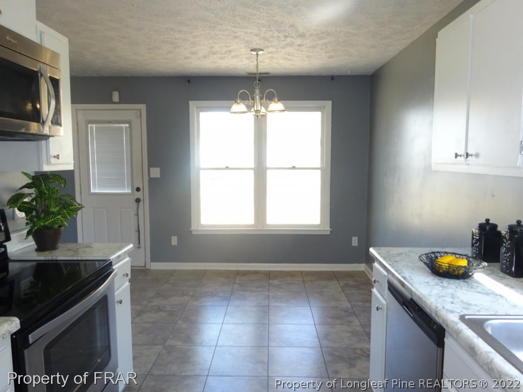 6528 Applewhite Road Fayetteville, NC 28304 - Photo 8 of 15 a kitchen with stainless steel appliances granite countertop a sink a stove and cabinets