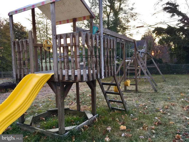 an empty room with wooden floor and kitchen view