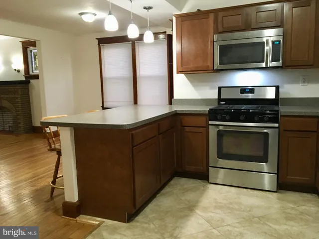 a kitchen with stainless steel appliances granite countertop a stove a microwave and a sink