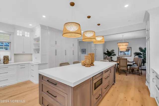 a kitchen with kitchen island white cabinets and refrigerator