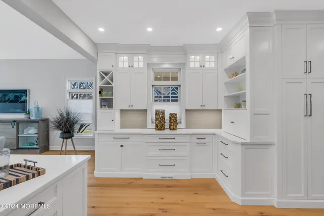 a kitchen with a sink white cabinets and stove