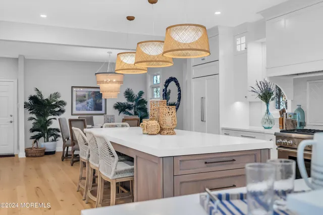 a kitchen with stainless steel appliances kitchen island granite countertop a table chairs sink and cabinets