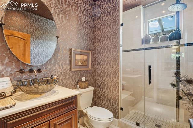 2204 Rocking Horse Court Colorado Springs, CO 80921 - Photo 29 of 50 Bathroom with vanity, walk in shower, backsplash, and toilet