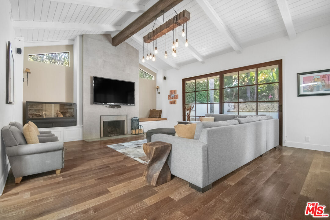 10353 Mississippi Avenue Los Angeles, CA 90025 - Photo 2 of 18 a living room with furniture a fireplace and a flat screen tv