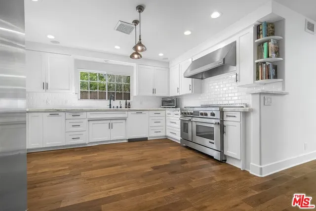 a kitchen with stainless steel appliances granite countertop a stove and a sink