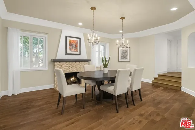 a dining room with furniture a chandelier and wooden floor