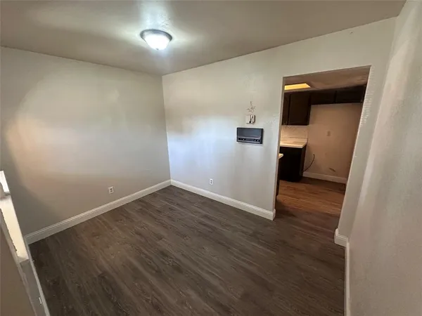 wooden floor in an empty room with a bathroom