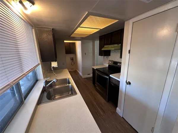 a bathroom with a granite countertop bathtub shower sink vanity and toilet