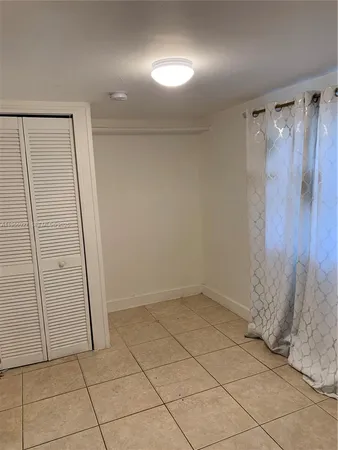 an empty room with wooden floor and brick walls