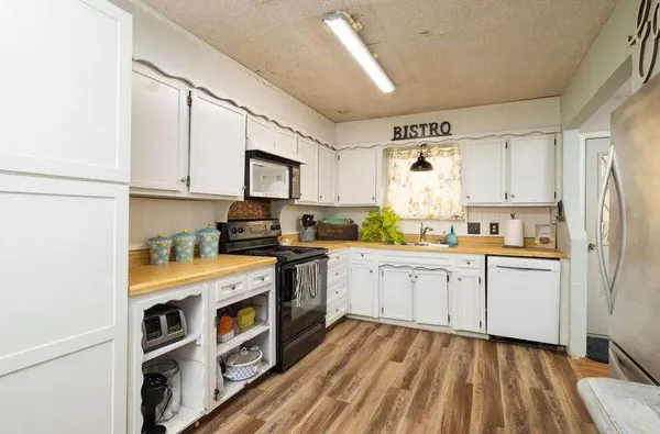 a kitchen with stainless steel appliances granite countertop a stove a sink and a refrigerator