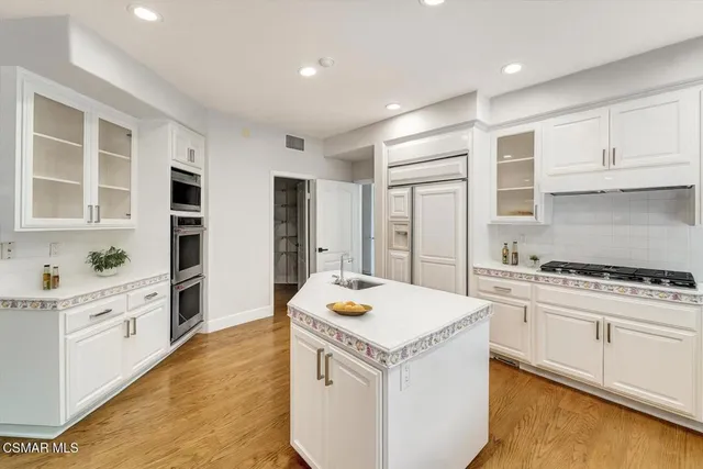 a kitchen that has a sink a stove and chairs
