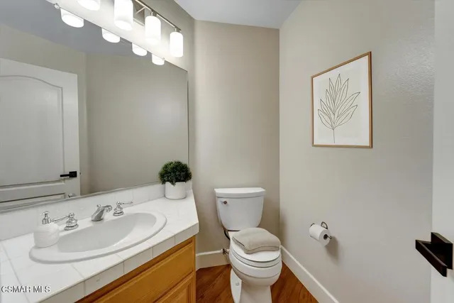 a bathroom with a toilet a sink and mirror